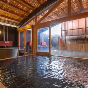 A hot spring bath with wooden railings and a view of the outside. - Iseya (Unzen)