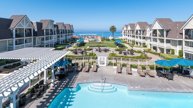 A resort with a swimming pool, lounge chairs, and a view of the ocean. - Carlsbad Inn Beach Resort (Carlsbad)