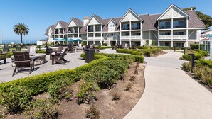 A resort with multiple-story buildings, outdoor seating areas, and a pathway leading to the beach. - Carlsbad Inn Beach Resort (Carlsbad)
