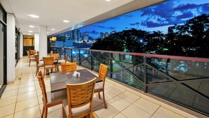 Un restaurante con terraza, vistas a la ciudad y un diseño moderno.