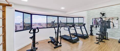 A gym with treadmills, elliptical machines, and weight equipment.