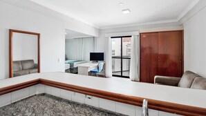 Una habitación de hotel moderna con cocina, una mesa de comedor, televisor y un armario grande.