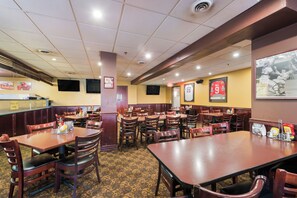 A restaurant with booths and tables, a counter, and sports memorabilia on the walls.