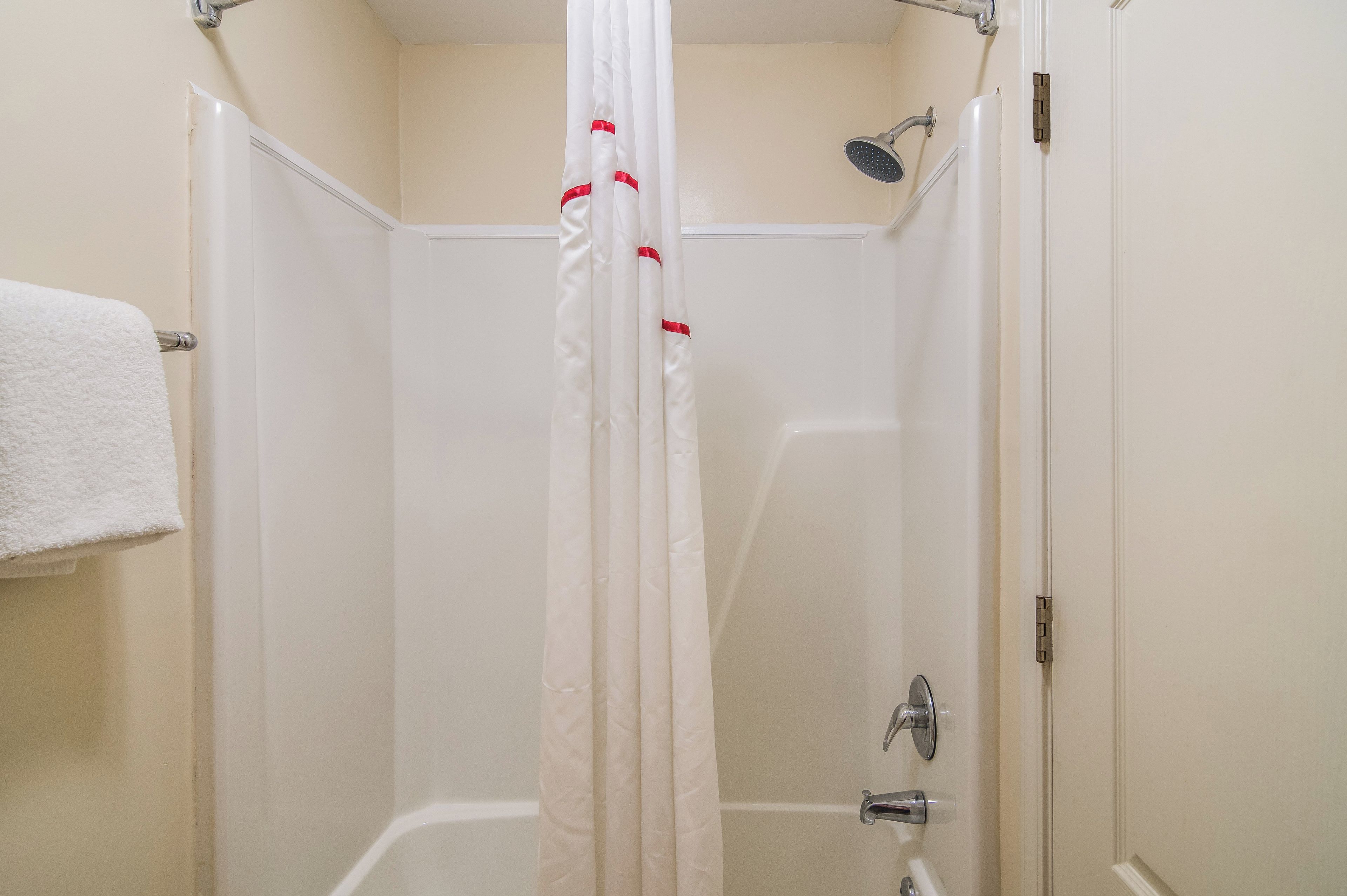 A bathroom with a shower, a bathtub, and a towel rack.