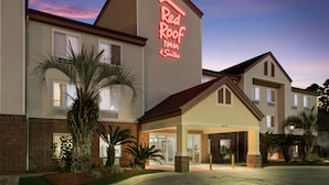 Un Red Roof Inn con 4 suites, que presenta fachada de ladrillo, ventanas amplias y una entrada bien iluminada.