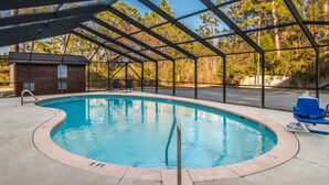 Una piscina cubierta al aire libre con un edificio de ladrillo y una señalización cercana.