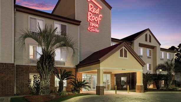 A Red Roof Inn with a brick facade and a large sign. - Red Roof Inn & Suites Pensacola East - Milton (Milton)
