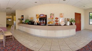 Zona de recepción con mostrador curvo, máquina de café y diversos alimentos a la vista.