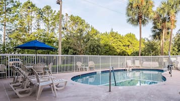 Una piscina al aire libre, sombrillas, sillones reclinables de piscina