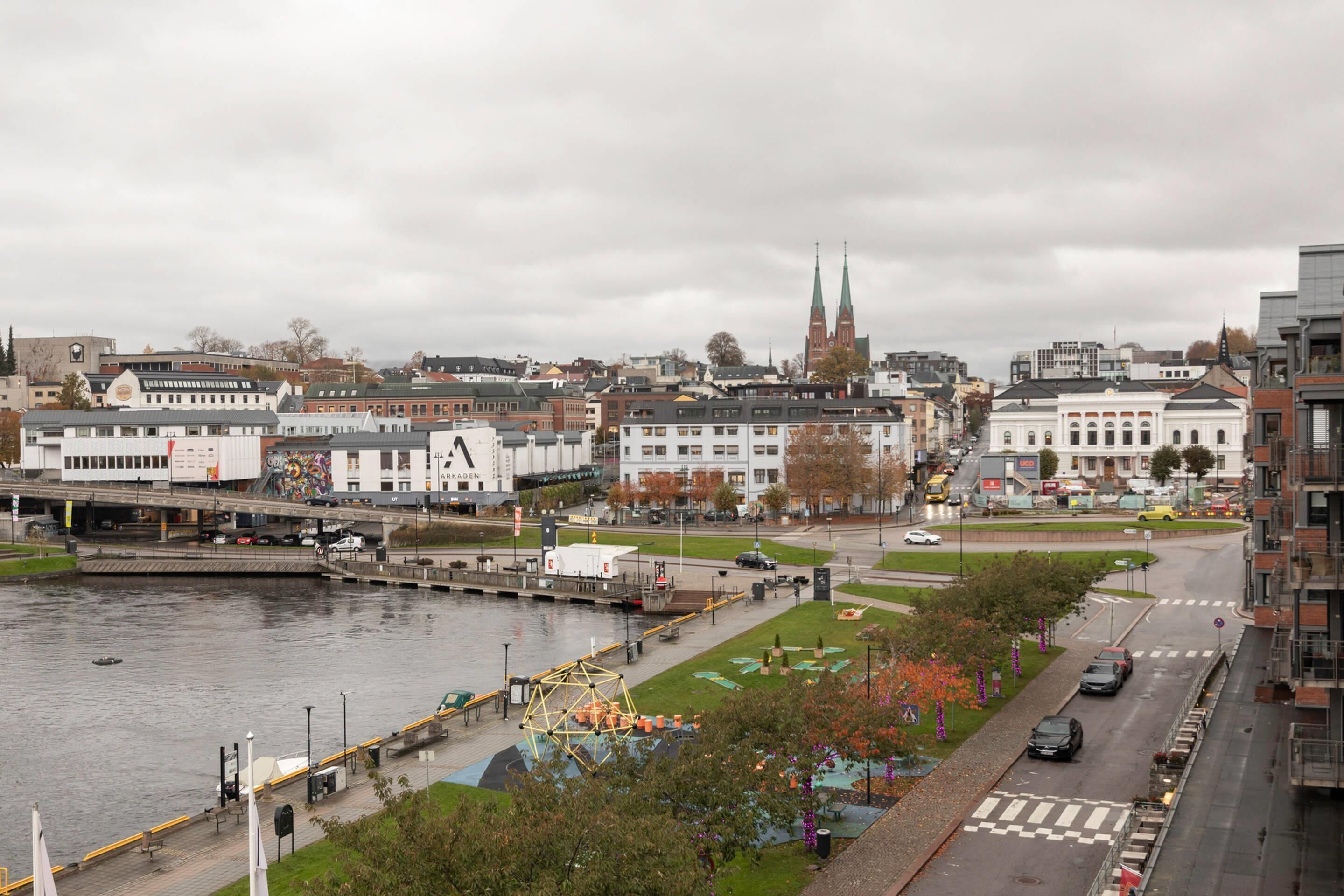 A cityscape with a river, buildings, and a bridge.