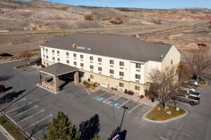 A Comfort Inn hotel with a parking lot, handicap-accessible spaces, and a mountainous backdrop.