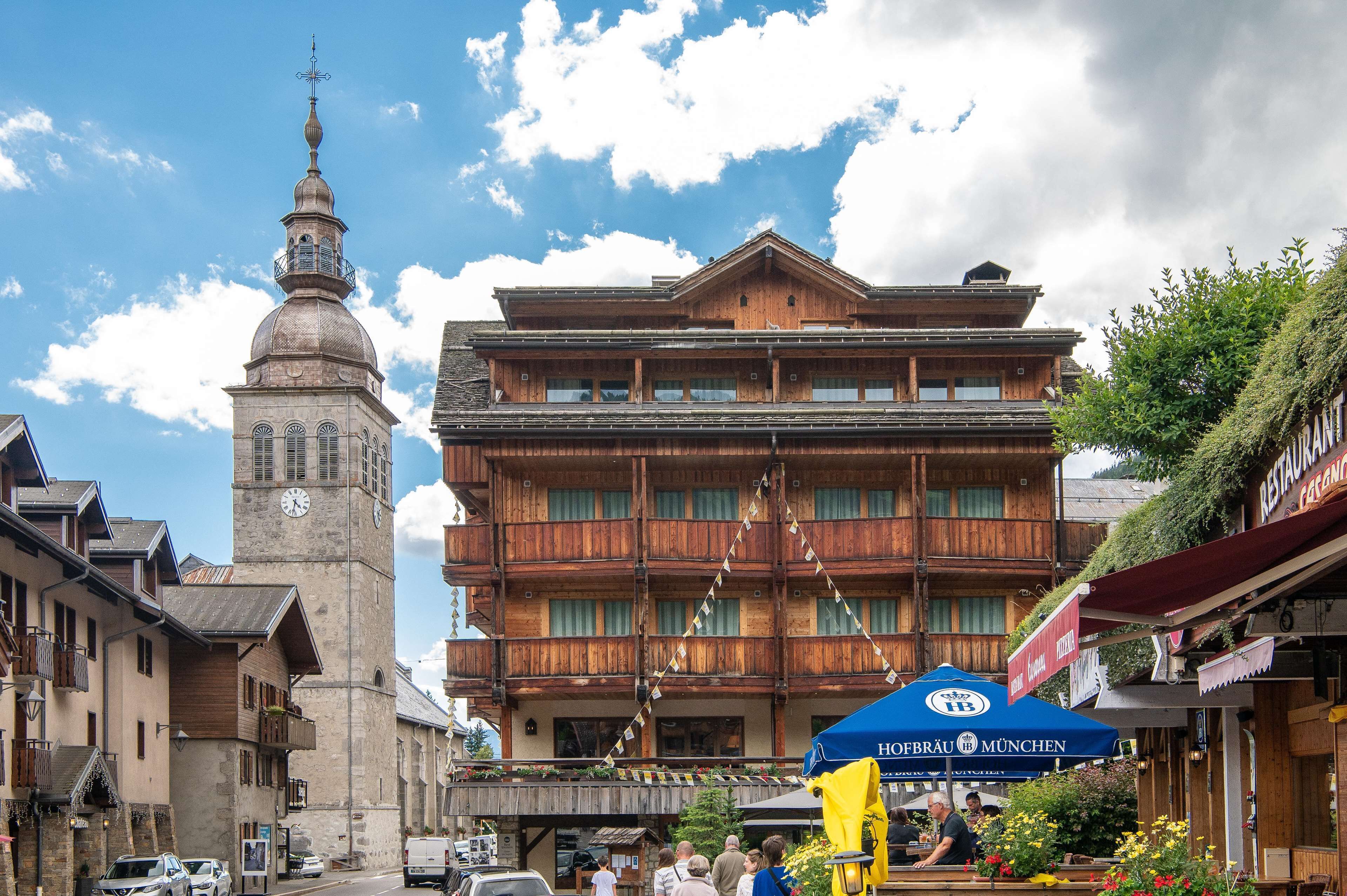 A historic building with a clock tower and a restaurant with outdoor seating.