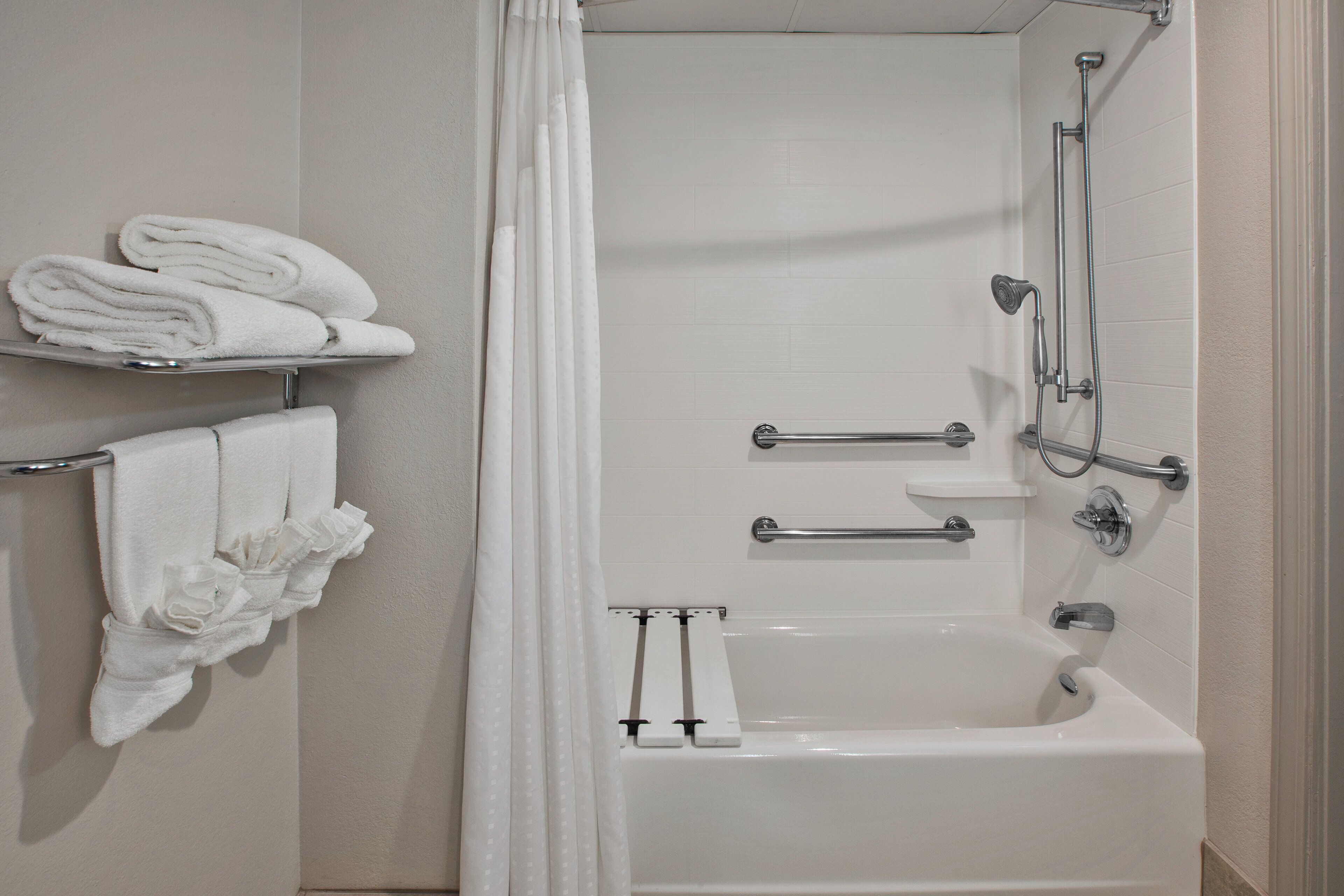 Un baño con bañera, ducha e inodoro. Hay toallas y una cortina de ducha.