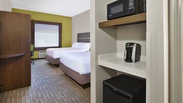 Une chambre d’hôtel équipée d’un lit, d’un four à micro-ondes, d’une machine à café et d’un réfrigérateur.