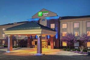 A Holiday Inn Express & Suites hotel with a covered entrance, brick facade, and illuminated signage. - Holiday Inn Express & Suites Manchester by IHG (Manchester)