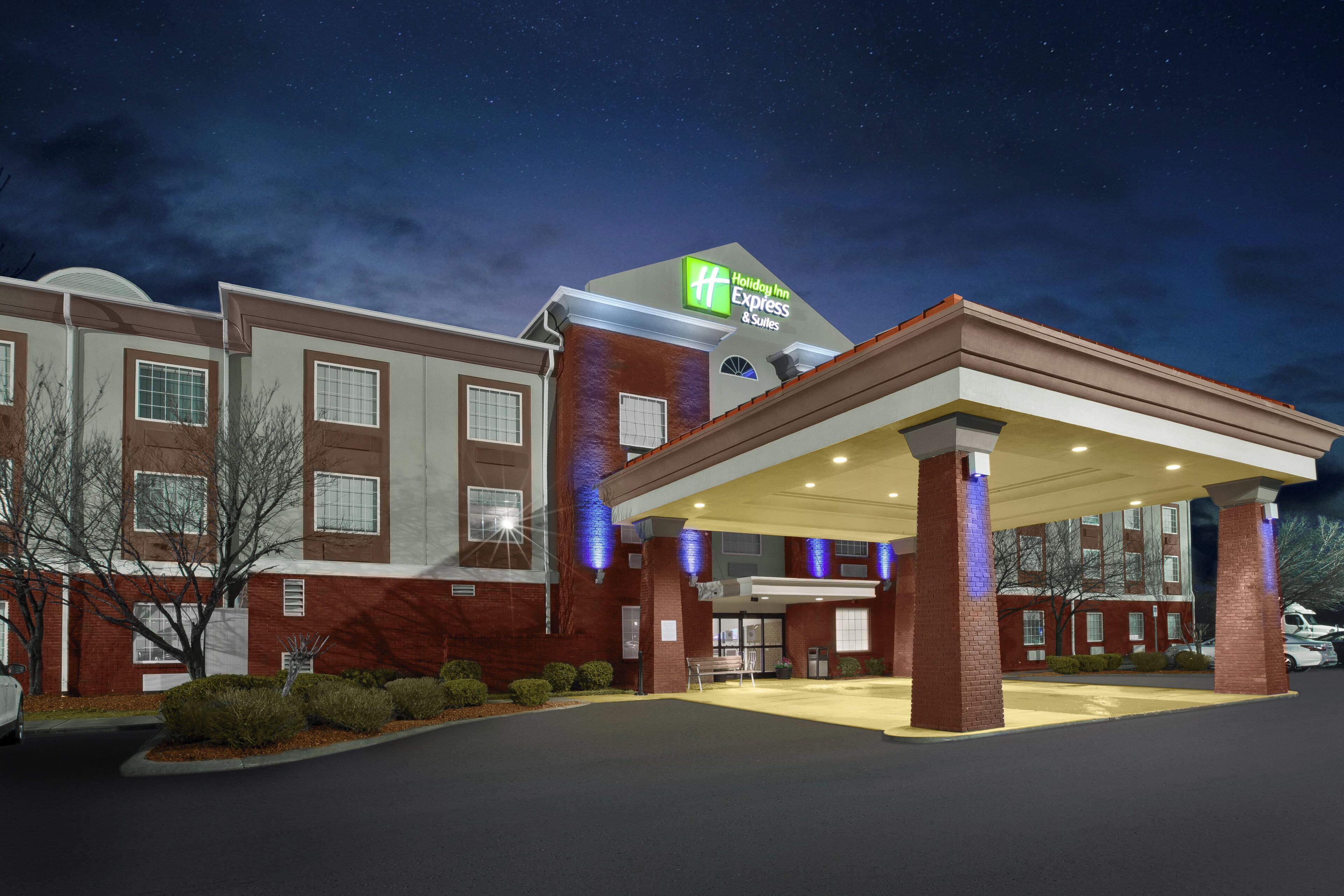 Et Holiday Inn Express & Suites hotel med overdækket indgang og murstensfacade.