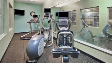 Un centre de remise en forme équipé de tapis de course, d’un vélo elliptique et d’un vélo d’appartement.