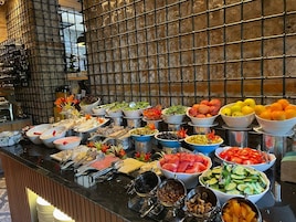 Un bufé con diferentes alimentos y utensilios.