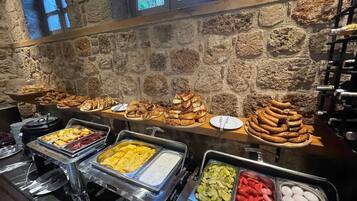A buffet with various food items including pastries, fruits, and vegetables.