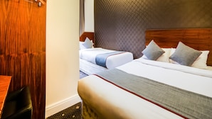 A hotel room with two beds, wooden headboards, a checkered wall, and a hanging coat rack. - The Park Hotel (London)