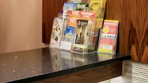 A display of travel brochures on a counter with a wooden backdrop. - The Park Hotel (London)
