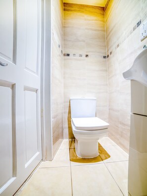 Habitación cuádruple Deluxe | Baño | Ducha, cabezal de ducha tipo lluvia y toallas