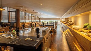 A restaurant with multiple tables, each set with wine glasses, cutlery, and napkins. - Occidental Tamarindo - All Inclusive (Tamarindo)