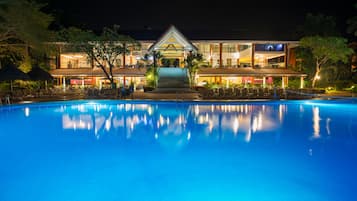 Una piscina al aire libre, sillones reclinables de piscina