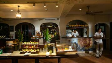 A restaurant with a buffet setup, a bar area, and a decorative ceiling.