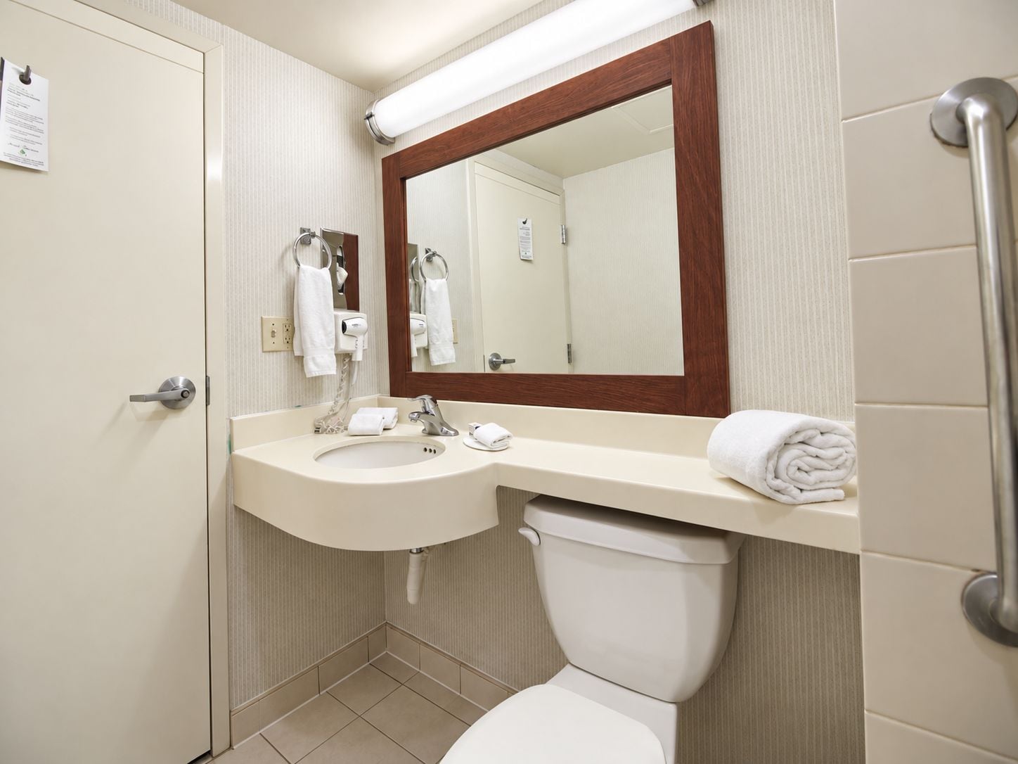 Baño con lavamanos, espejo e inodoro.