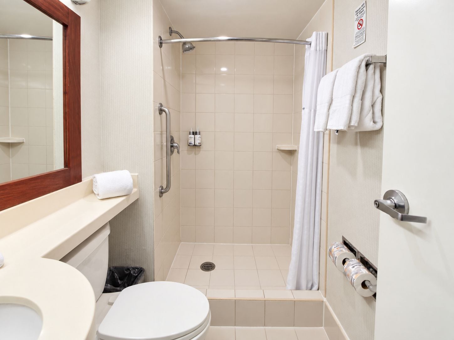 A bathroom with a shower, toilet, and sink.