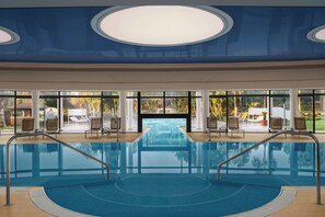 Een binnenzwembad, een buitenzwembad, parasols voor strand/zwembad