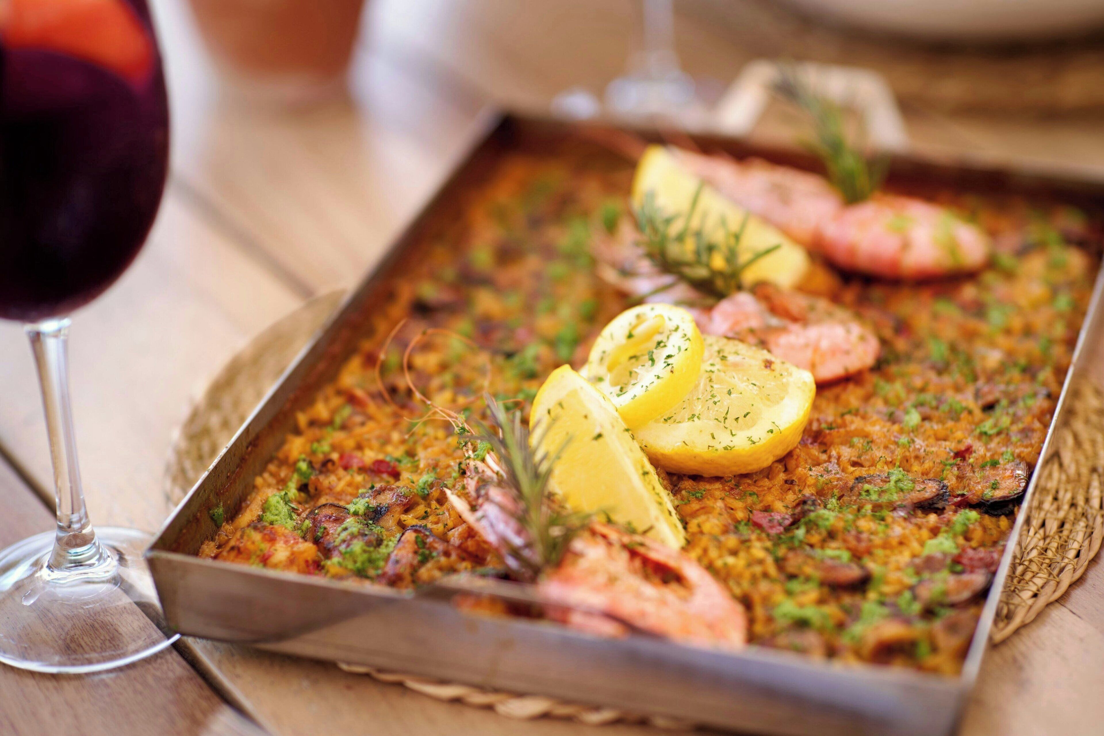 Un plato con mariscos y rodajas de limón sobre una bandeja.
