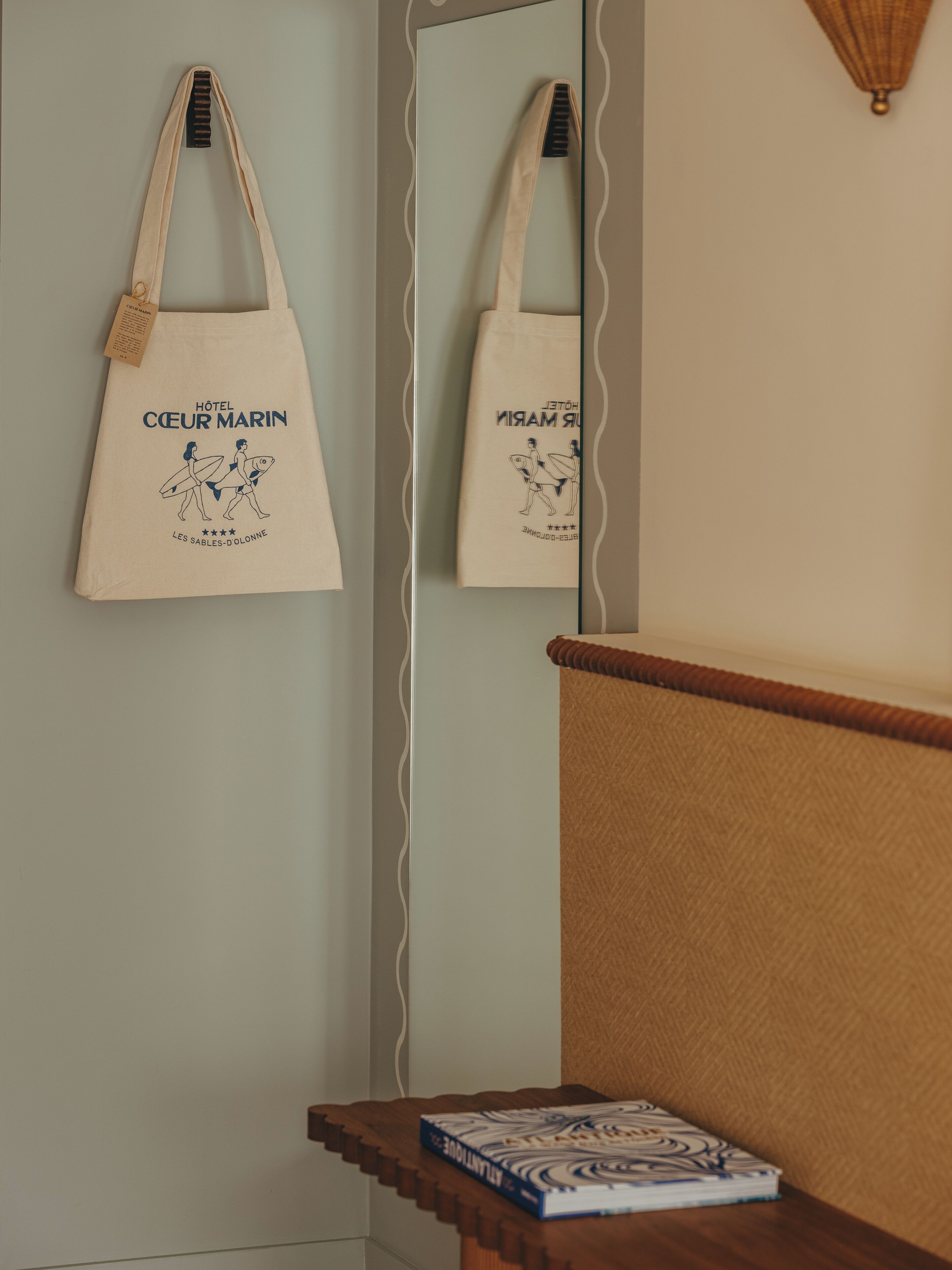 Ein Zimmer mit einer hölzernen Sitzbank, einem Spiegel und einer Tasche mit einem Muster.
