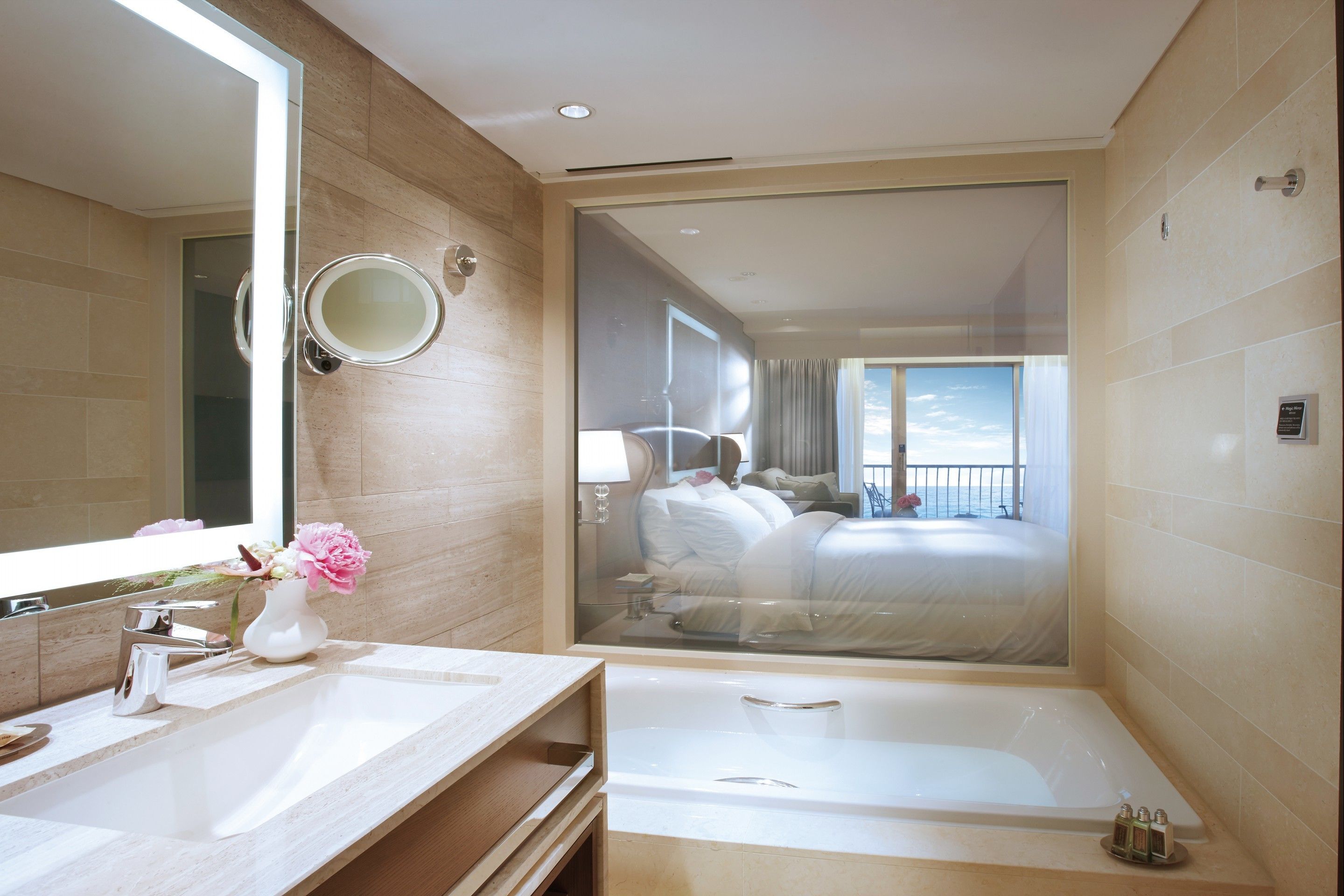 A modern bathroom with a large mirror, a sink, and a bathtub.