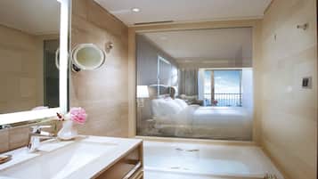 A modern bathroom with a large mirror, a sink, and a bathtub.