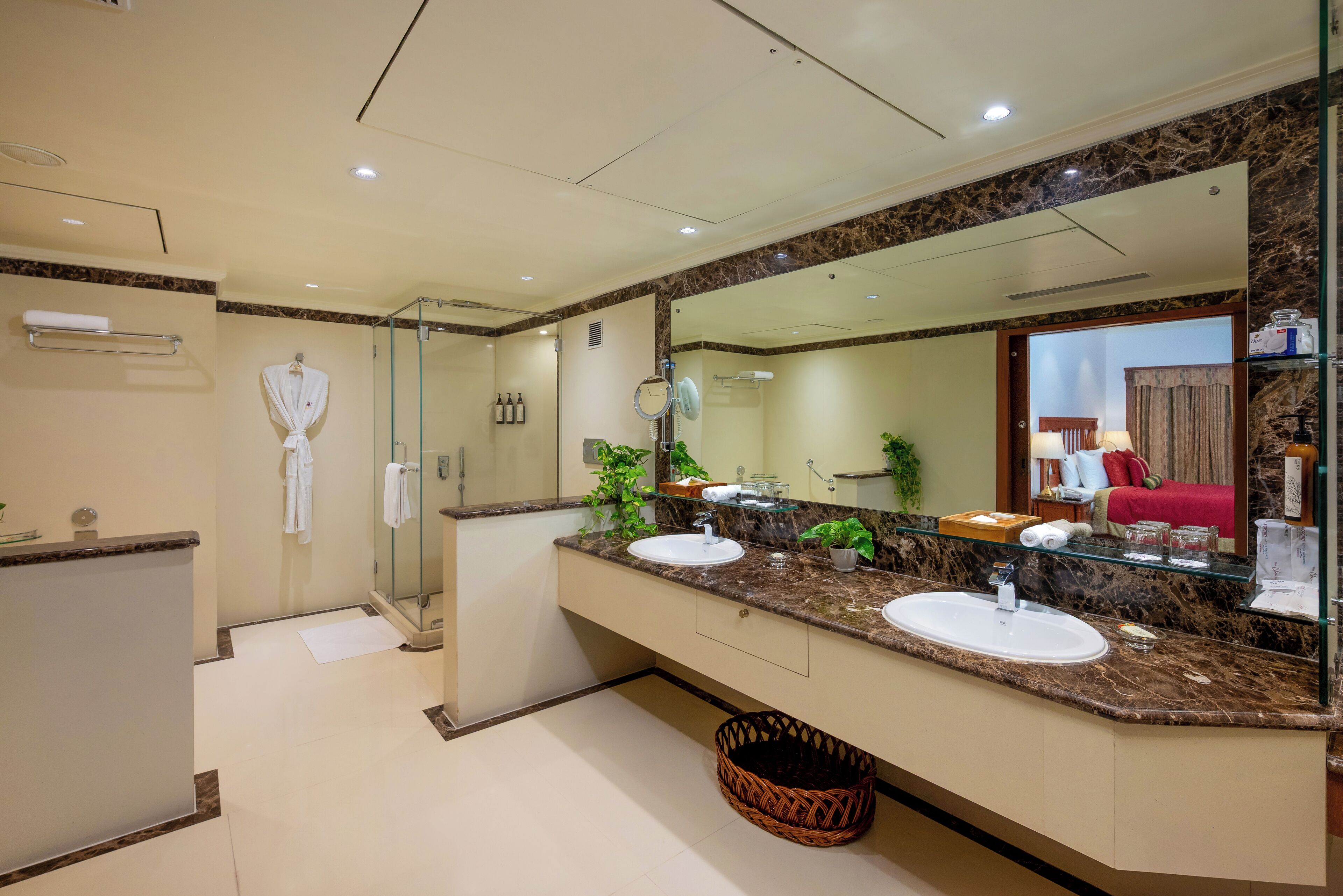 Un bagno moderno con due lavabi, un grande specchio e uno spazio doccia in vetro.