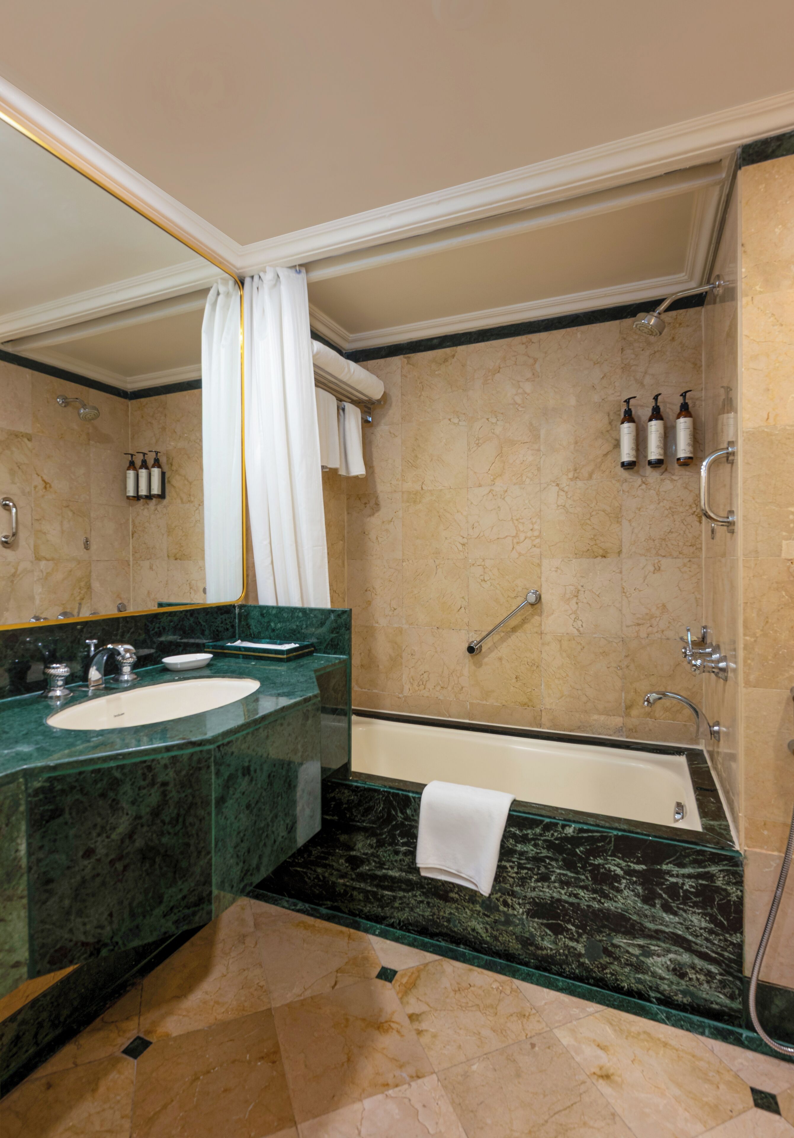 A bathroom with a marble sink, a bathtub, and a shower.