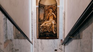 A marble staircase with a central statue of a seated figure. - Hotel Pantheon (Rome)