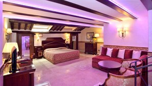A hotel room with a bed, a sofa, a desk with a lamp, and a TV. - Hotel Pantheon (Rome)