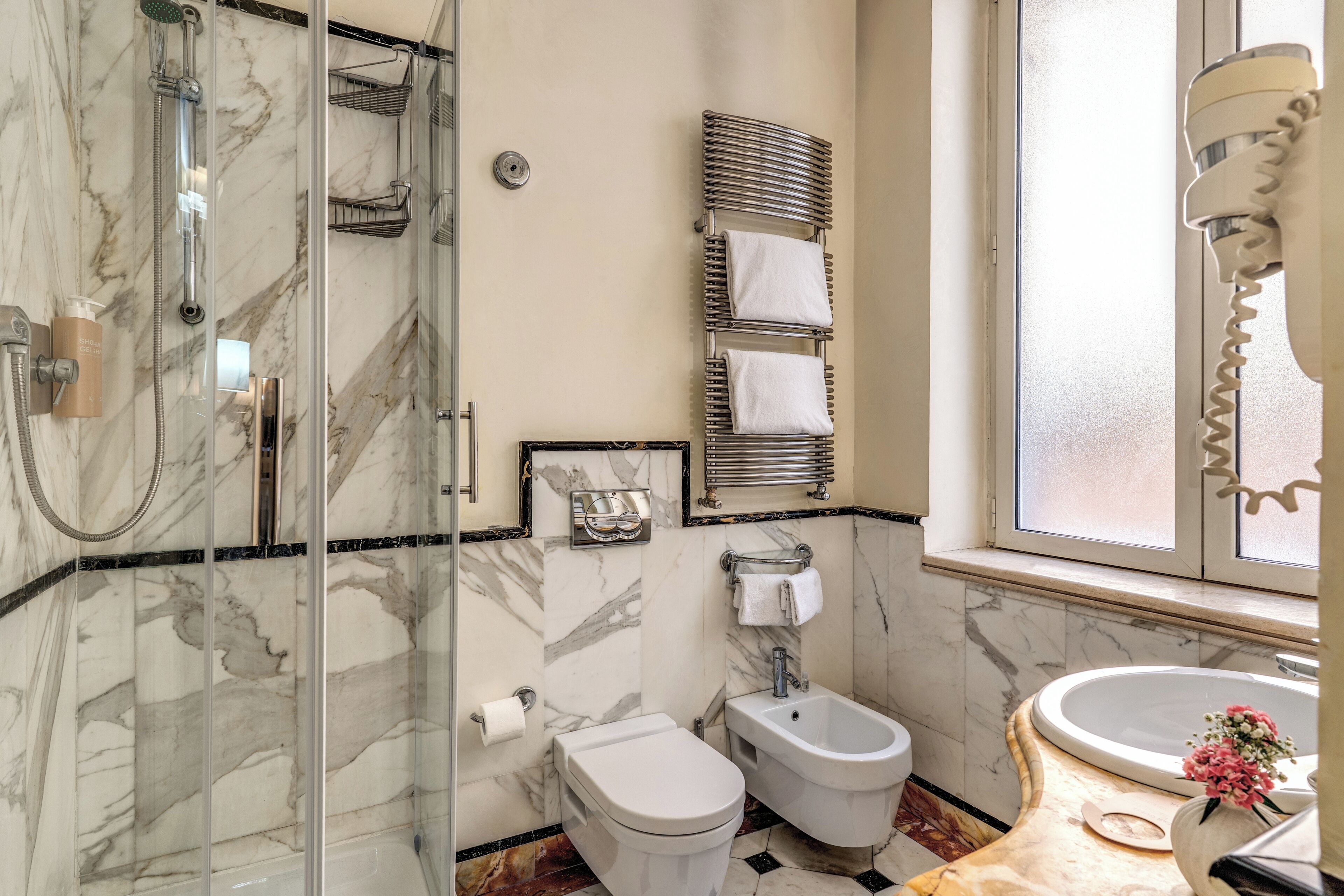 Ein Badezimmer mit Dusche, Toilette, Bidet und Waschbecken.