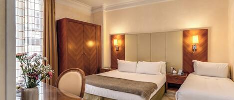 A hotel room with a bed, bedside tables, a desk, and a chair.