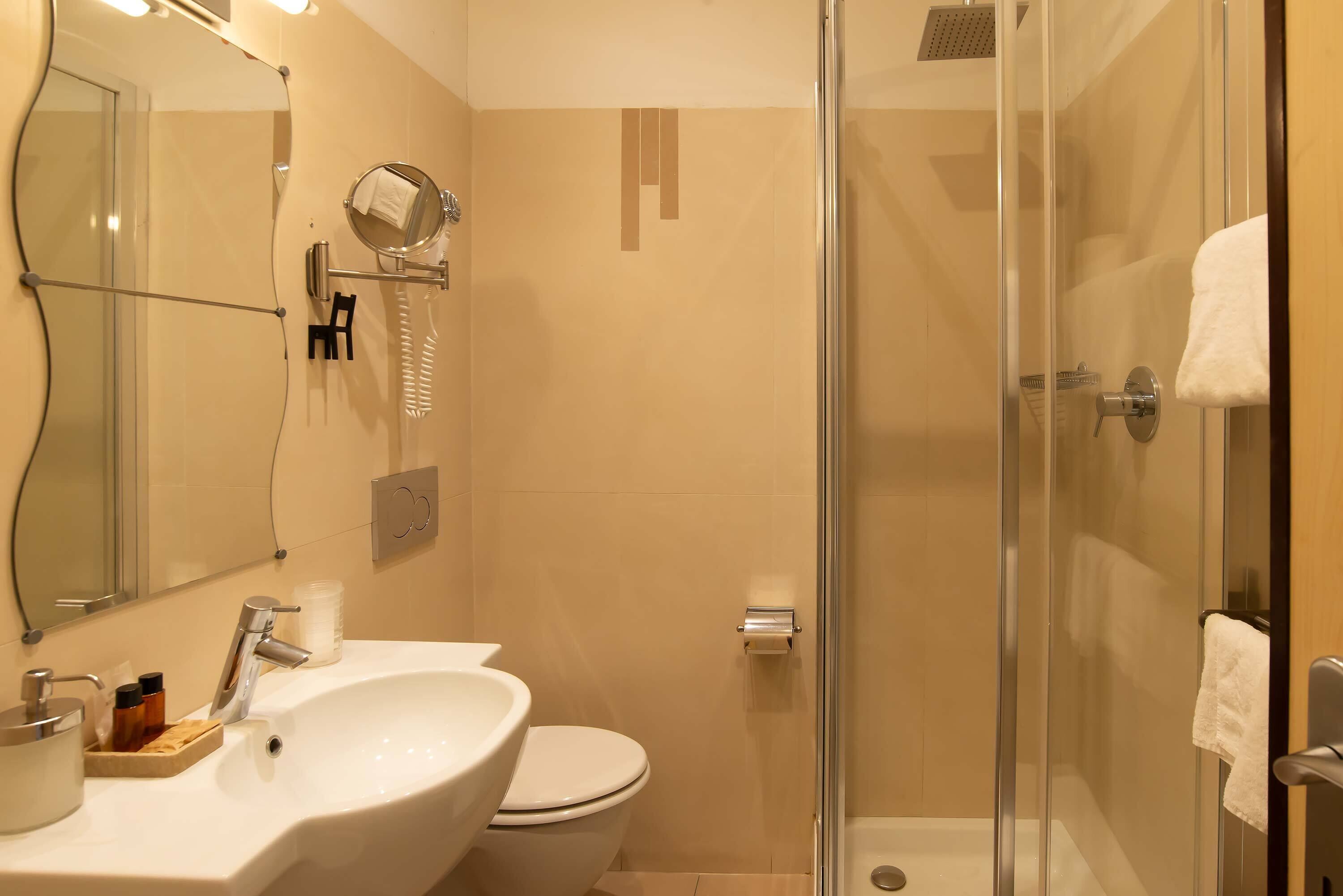 Un baño moderno con ducha de vidrio, lavamanos y retrete.