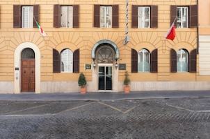 A building with a symmetrical facade, arched windows, and a central entrance with a door.
