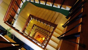 A multi-level wooden staircase with a central landing area. - Hotel Meridiana (Florence)