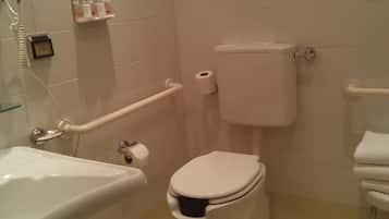 A bathroom with a white toilet, a white sink, and a white bathtub. There is a hand dryer mounted on the wall next to the sink.