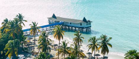 En la playa, arena blanca, sillas reclinables de playa, sombrillas