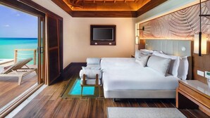 Une chambre spacieuse avec un grand lit, une télévision et une vue sur l’océan.