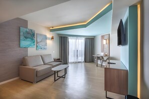 Un salon moderne avec un canapé, une table basse et un téléviseur fixé au mur.