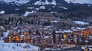 Une montagne enneigée, avec une station de ski en arrière-plan.